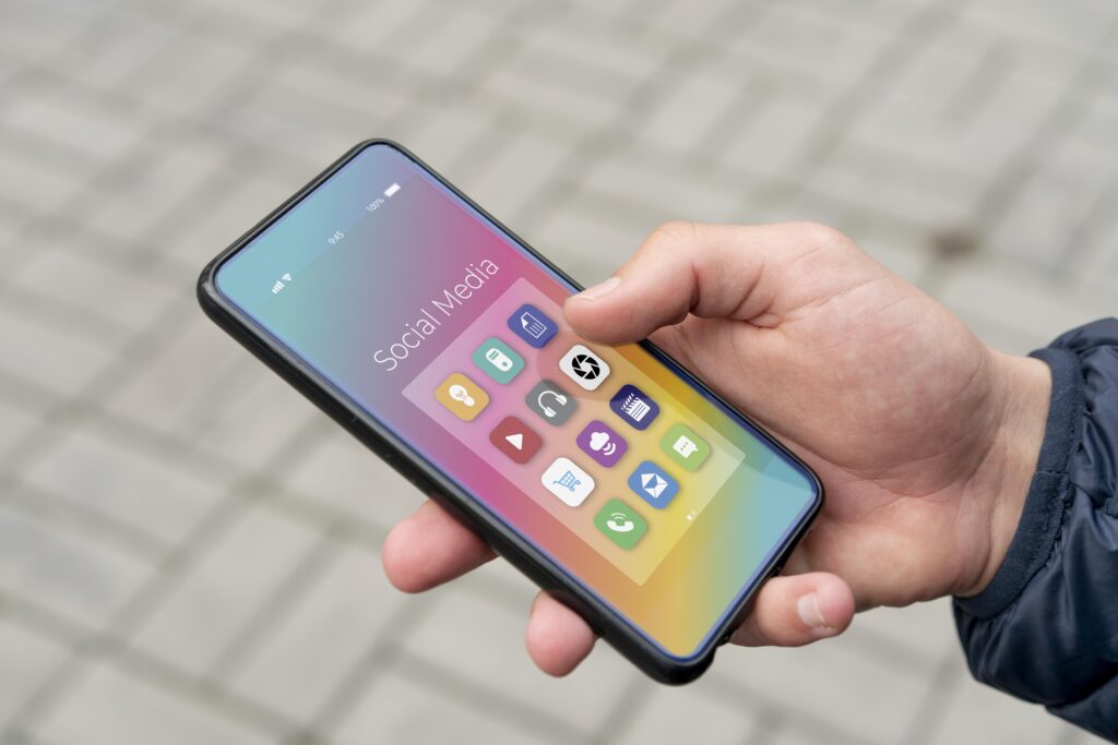 celular na mão de uma pessoa com aplicativos à mostra